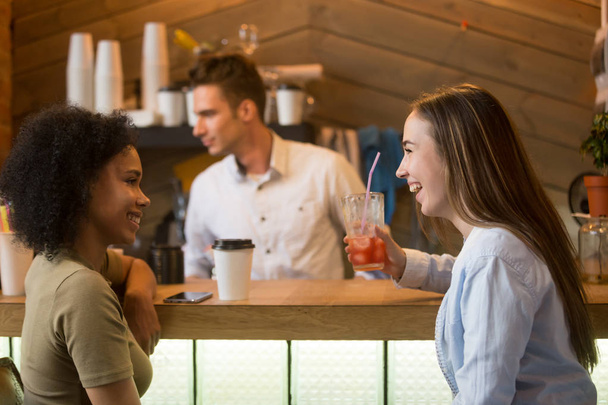 Multiracial girlfriends laughing, enjoying drinks at bar counter - Photo, Image