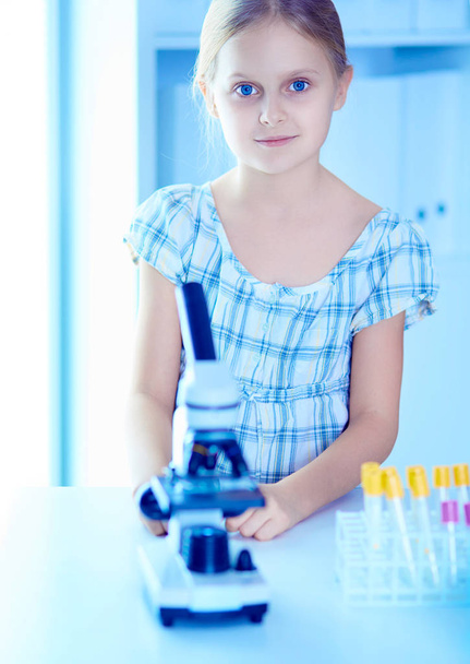 Schoolgirl looking through microscope in science class. - Φωτογραφία, εικόνα