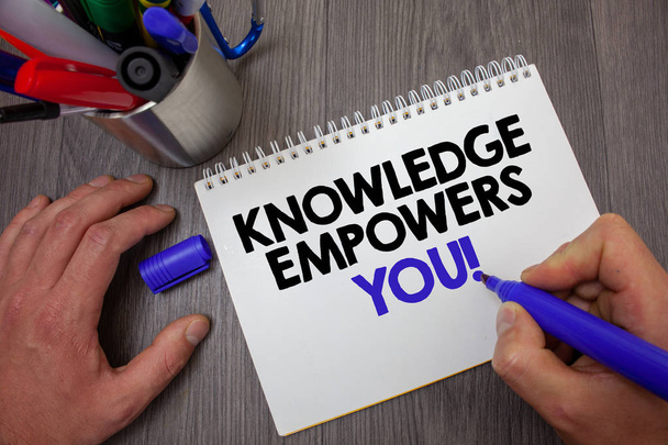 Text sign showing Knowledge Empowers You Call. Conceptual photo Education responsible to achieve your success Man hold holding blue marker notebook page markers table messages ideas - Photo, image