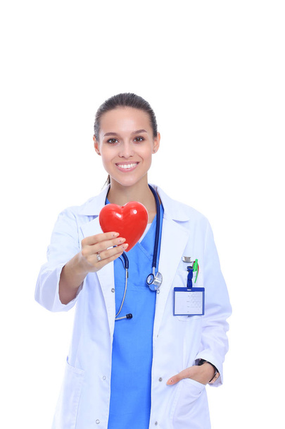 Positive female doctor standing with stethoscope and red heart symbol isolated. Woman doctor - Foto, Imagem