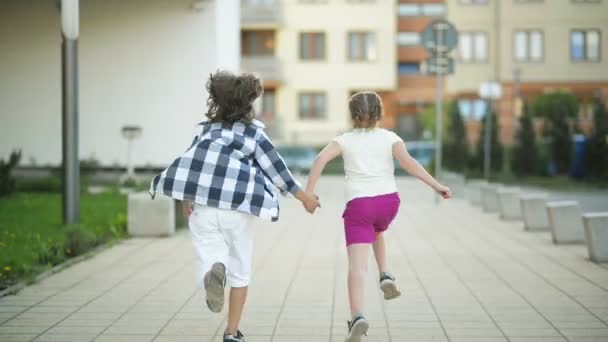 Two Happy Children Run Together Holding Hands. Their Blond Hair Wave Out On The Wind. - Filmagem, Vídeo