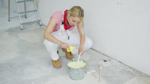 Woman mixing wall paint in bucket  - Footage, Video