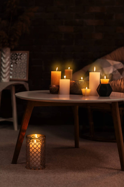 Burning candles on table indoors - Фото, зображення