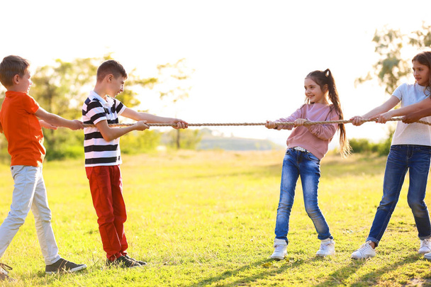Cute little children playing with rope outdoors on sunny day - Foto, Bild