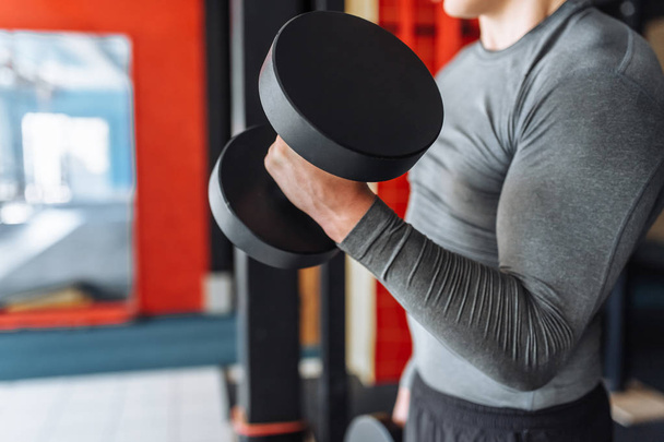 Sports man raises weights in training in the gym - Fotoğraf, Görsel