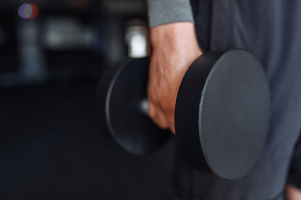 Sports man raises weights in training in the gym - Foto, Bild