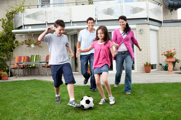 Happy family playing football in their backyard - Foto, immagini