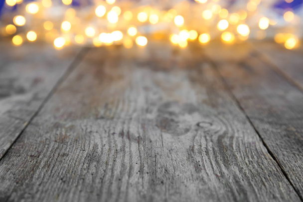 Wooden table and blurred Christmas lights on background - Foto, Imagem
