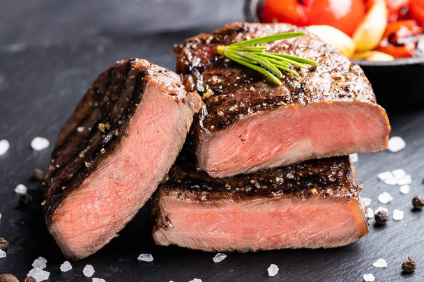 Close-up of steak Top Blade roasting medium ready to eat on dark stone background - Photo, Image