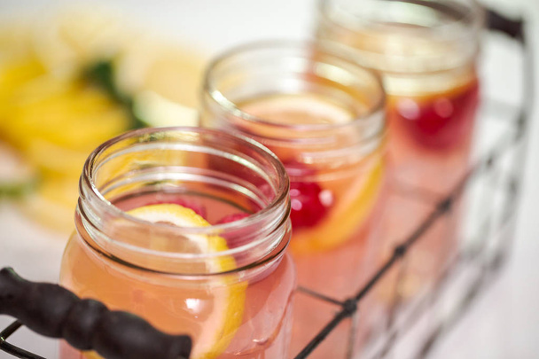 Limonada de framboesa em jarros de pedreiro de bebida em uma mesa branca
. - Foto, Imagem
