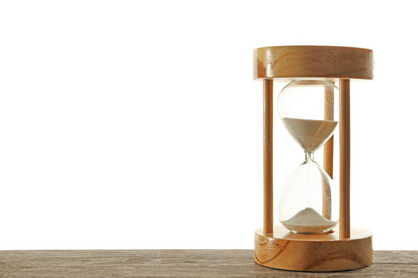 Hourglass with flowing sand on table against light background. Time management - Photo, Image