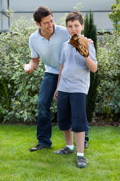 Cute little boy playing baseball with his father - Fotó, kép