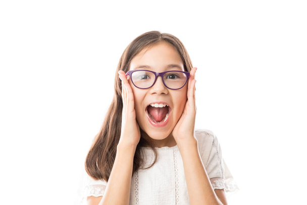 Verrast meisje in bril met geopende mond in vreugde houden van de zijkanten van het gezicht met handen  - Foto, afbeelding