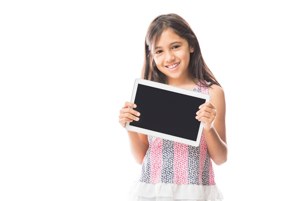 Charmante, mooie kleine dame bedrijf van moderne digitale tablet-pc in handen met een zwart leeg scherm geïsoleerd op witte achtergrond  - Foto, afbeelding