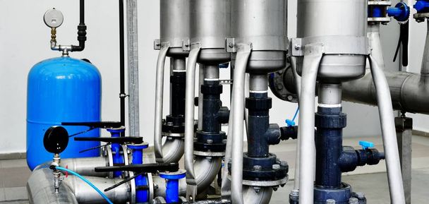 Gran tratamiento de agua industrial y sala de calderas. Tubos metálicos de acero brillante y bombas y válvulas azules. - Foto, imagen