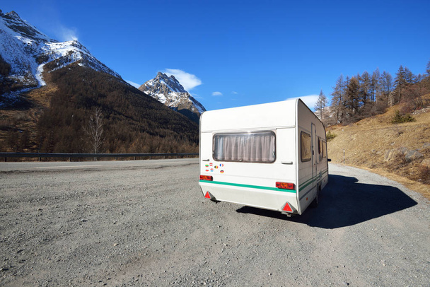 Caravana com uma bicicleta estacionada em uma estrada de asfalto nas montanhas Fench Alps. Parc Ecrins
 - Foto, Imagem