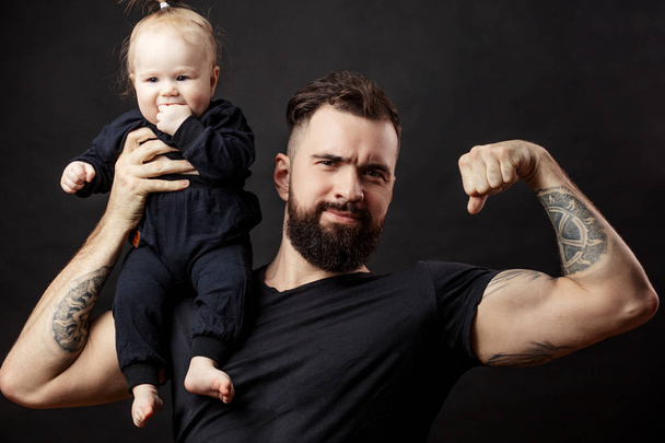 Мускулистый отец держит своего малыша - Фото, изображение