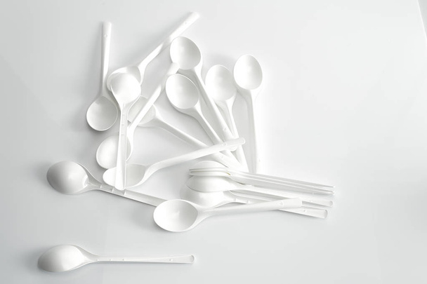 weißer Löffel auf weißem Hintergrund, Konzept der Nahrungsmittelknappheit - Foto, Bild