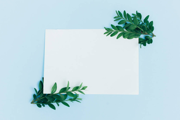 Desktop mock-up with blank paper card, branch on white shabby table background. Empty space. Styled stock photo, web banner. Flat lay - Fotoğraf, Görsel