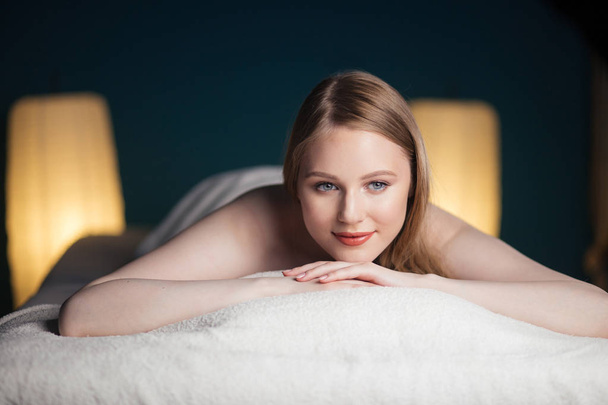 Young, beautiful woman in spa salon lying on the coach waiting for massage. - Zdjęcie, obraz