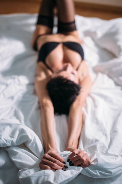 Satisfied sexy woman lying on bed - Photo, image
