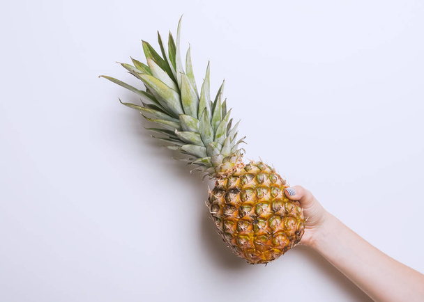 Womans hand holding pineapple - Φωτογραφία, εικόνα