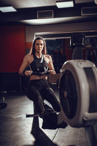  woman pulling the rowing machine - Photo, Image