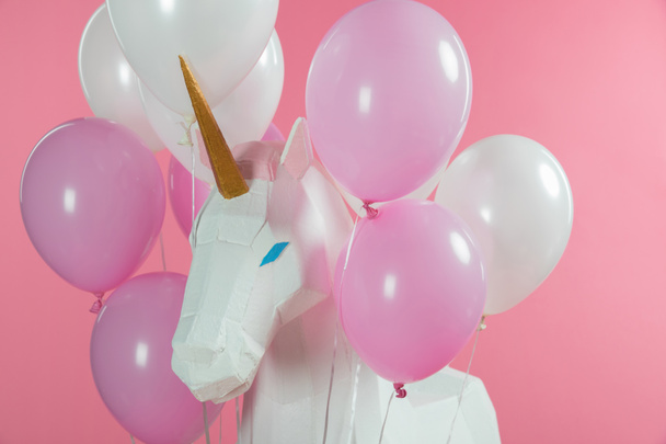 Magical unicorn with bunch of balloons isolated on pink - Photo, Image