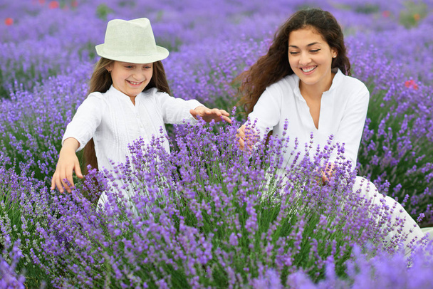 giovane donna e ragazza sono nel campo della lavanda, bellissimo paesaggio estivo con fiori di papavero rosso
 - Foto, immagini