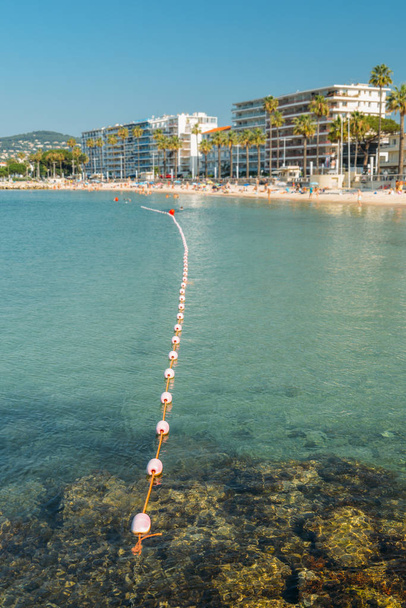 De manhã cedo banhistas de sol não identificáveis e natação na praia Juan les Pins, um destino popular resort no Mediterrâneo
 - Foto, Imagem