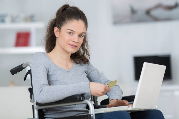 girl on a wheelchair buying online - 写真・画像