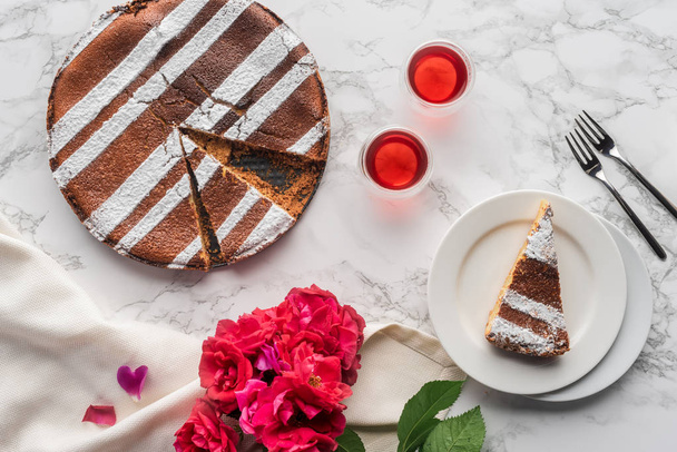 おいしい自家製ケーキと美しい赤い花の大理石の表面観トップ - 写真・画像