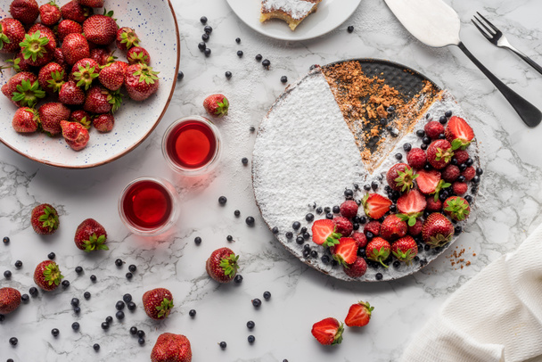 top view of delicious homemade cake with fresh berries on marble surface   - Foto, afbeelding