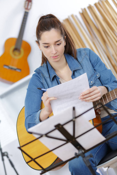 women compose song and play guitar - Φωτογραφία, εικόνα