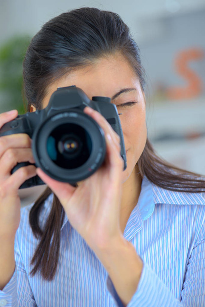 fotógrafa sosteniendo una cámara profesional
 - Foto, Imagen