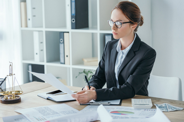 attractive financier working with documents at table in office  - Photo, Image