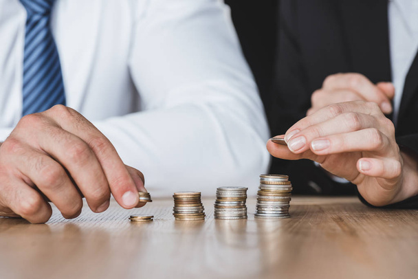 cropped image of financiers stacking coins on table in office - Photo, Image