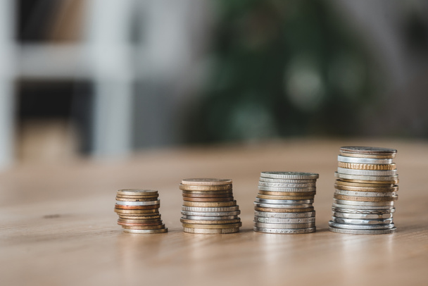 Stapels munten op houten tafelblad in financiële kantoor - Foto, afbeelding