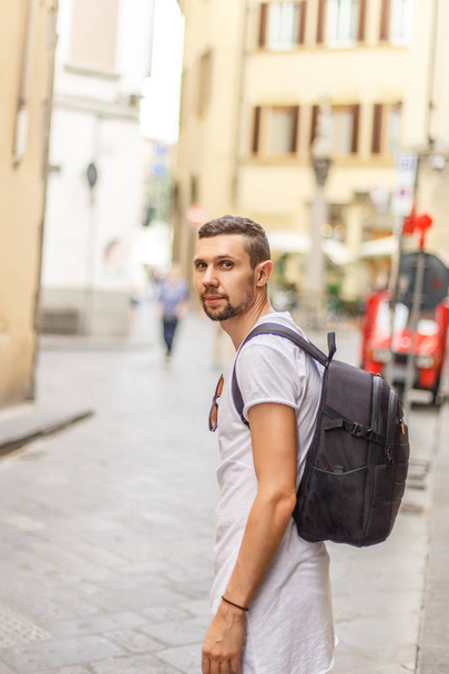 Side view of young man with backpack on street - Foto, Bild