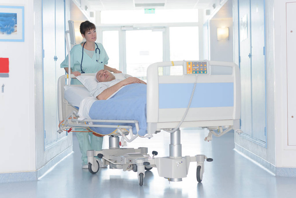 portrait of nurse pushing stretcher in hospital - Фото, изображение