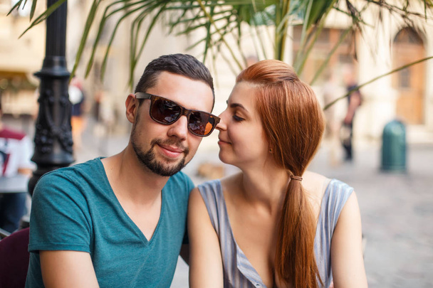 Young couple in love sitting next to each other in street cafe - Foto, Bild