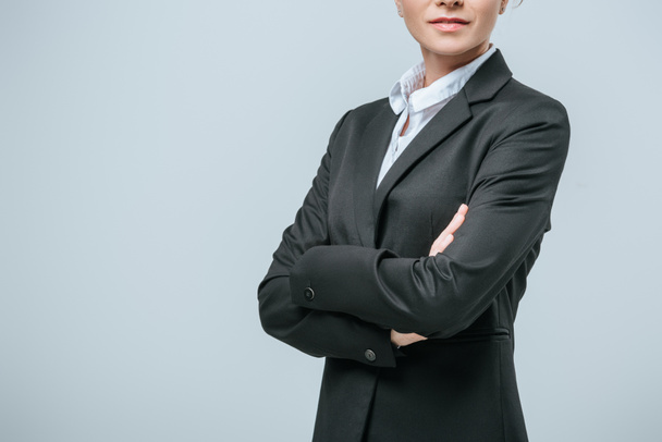 cropped image of businesswoman standing with crossed arms isolated on grey - Photo, Image