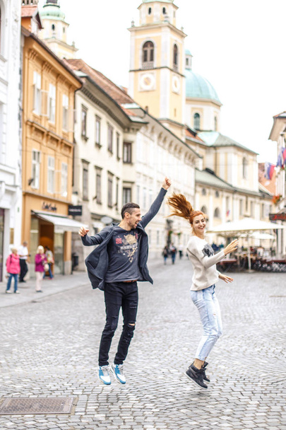 若いカップル ジャンプ、リュブリャナ、スロベニアの歩行者通りに楽しんで - 写真・画像