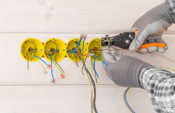 manos del electricista instalando enchufe eléctrico con destornillador en la pared
 - Foto, Imagen