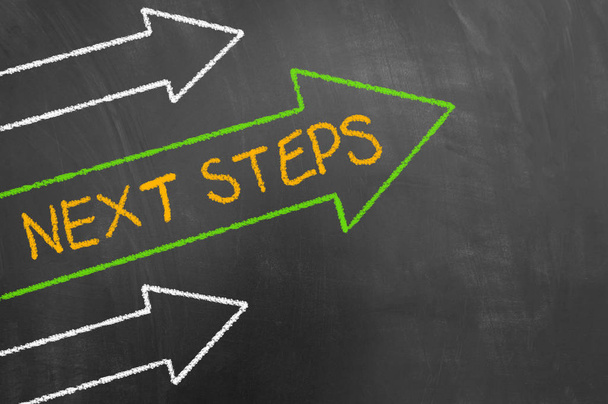 Next steps progress concept with chalk text and direction arrows on blackboard or chalkboard - Photo, Image