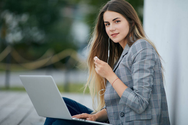 Chica bonita sentarse con su ordenador portátil y estilizado. Fondo blanco
 - Foto, Imagen