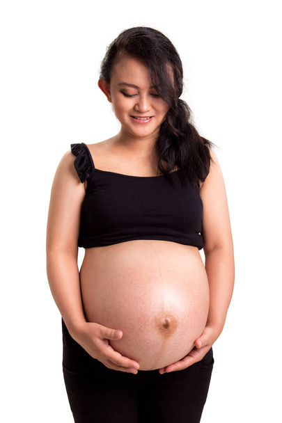 Siyah top karnı beyaz arka plan üzerinde izole, sevecen hamile anne portresi - Fotoğraf, Görsel