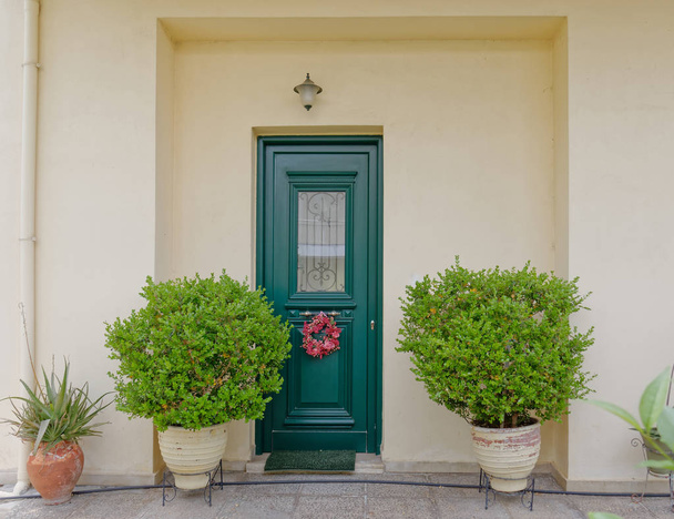Ateena Kreikka, viihtyisä talon sisäänkäynti vihreä ovi ja kasvit
 - Valokuva, kuva