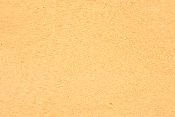 Achtergrond van een gele stucwerk bekleed en geschilderd buitenkant, ruwe cast van cement en betonnen muur textuur, decoratieve rustieke coating - Foto, afbeelding