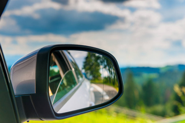 car mirror with reflection of a beautiful landscape in it, close-up - Foto, Imagem
